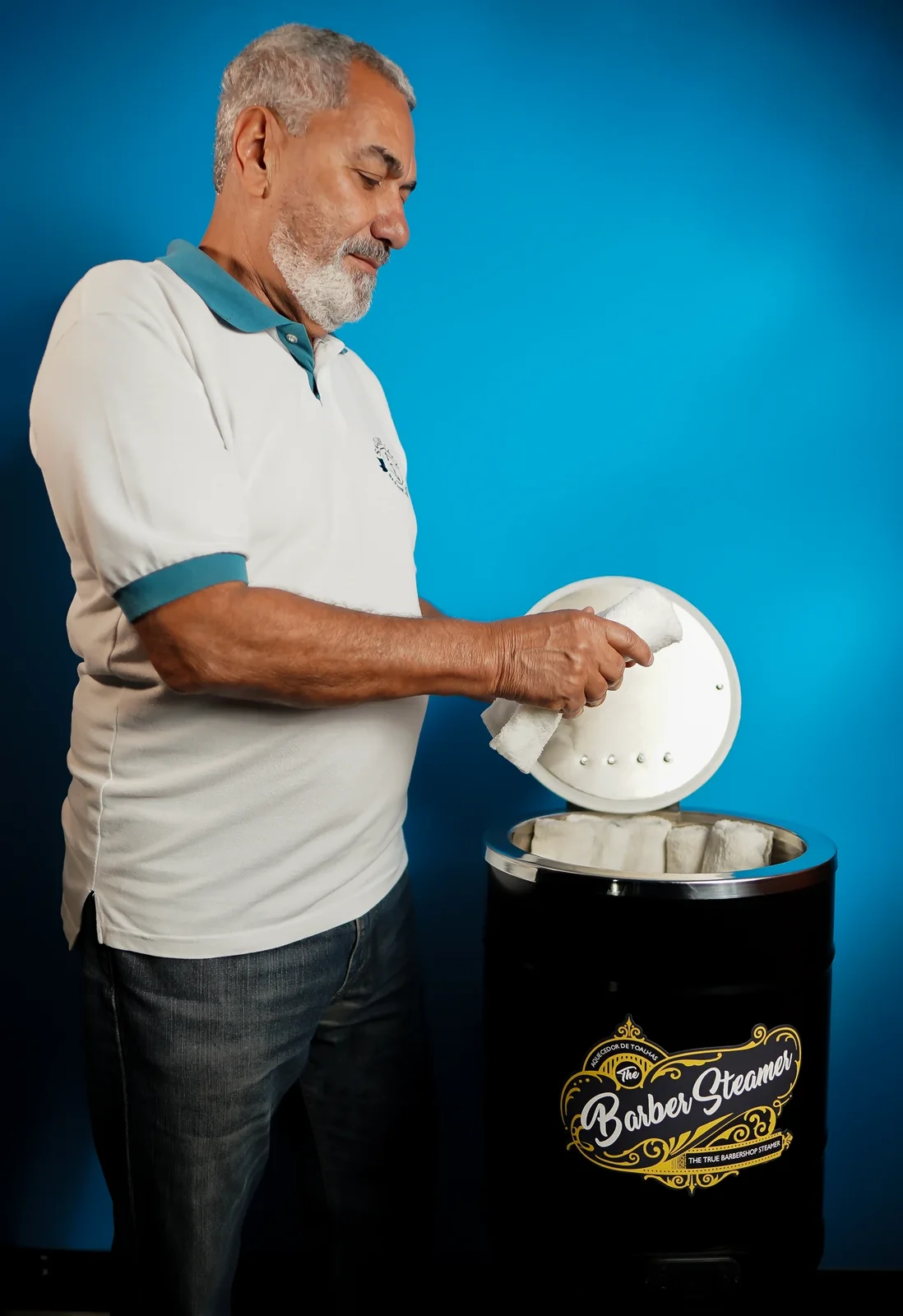 Profissional retirando toalha quente do Barber Steamer